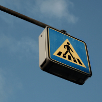 Das Verkehrszeichen "Zebrastreifen vor einem blauen Himmel von schräg unten fotografiert.
